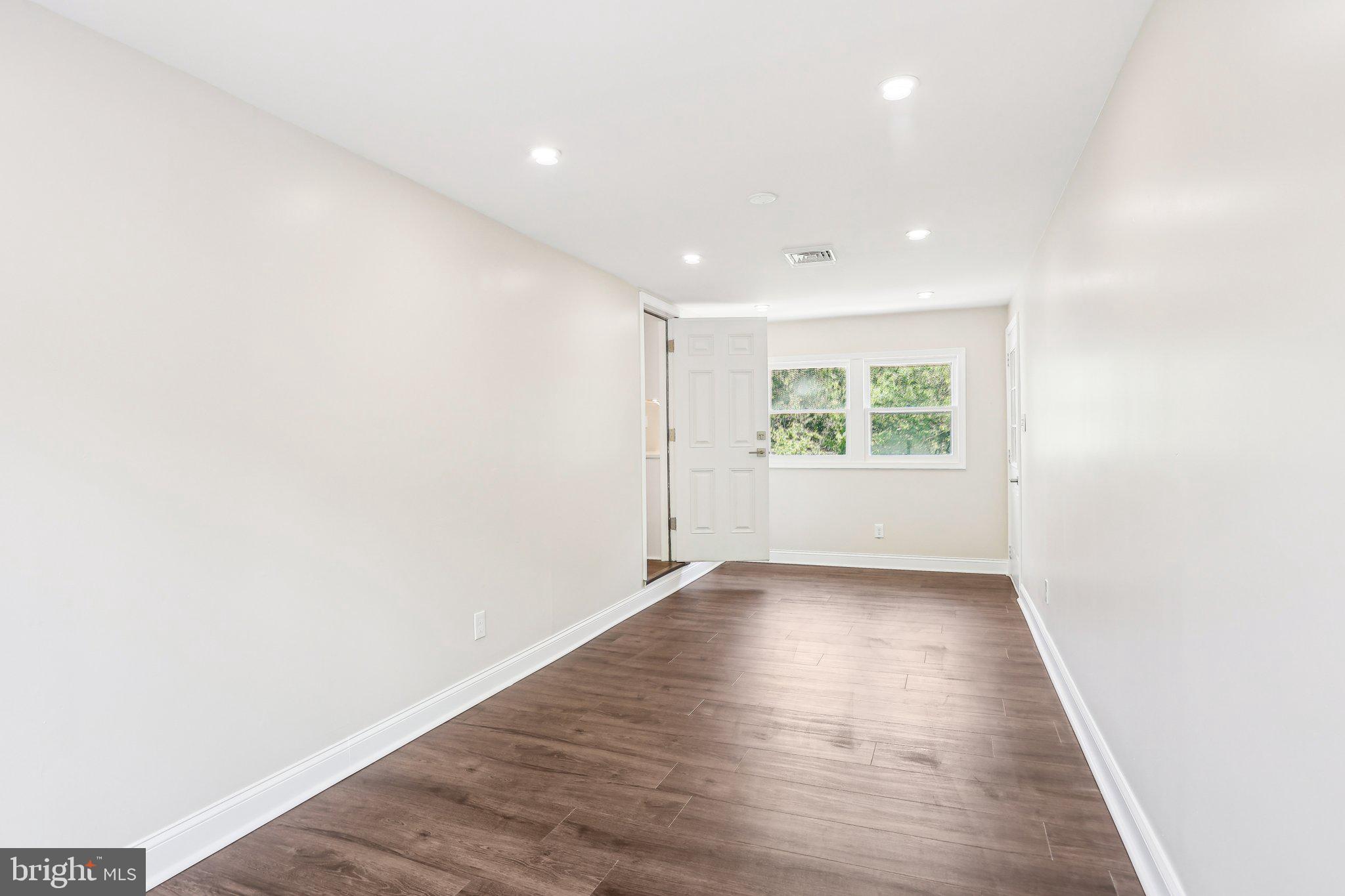 302 Fenwick Road Pilesgrove, NJ 08098 - Photo 23 of 51 a view of an empty room with wooden floor and a window