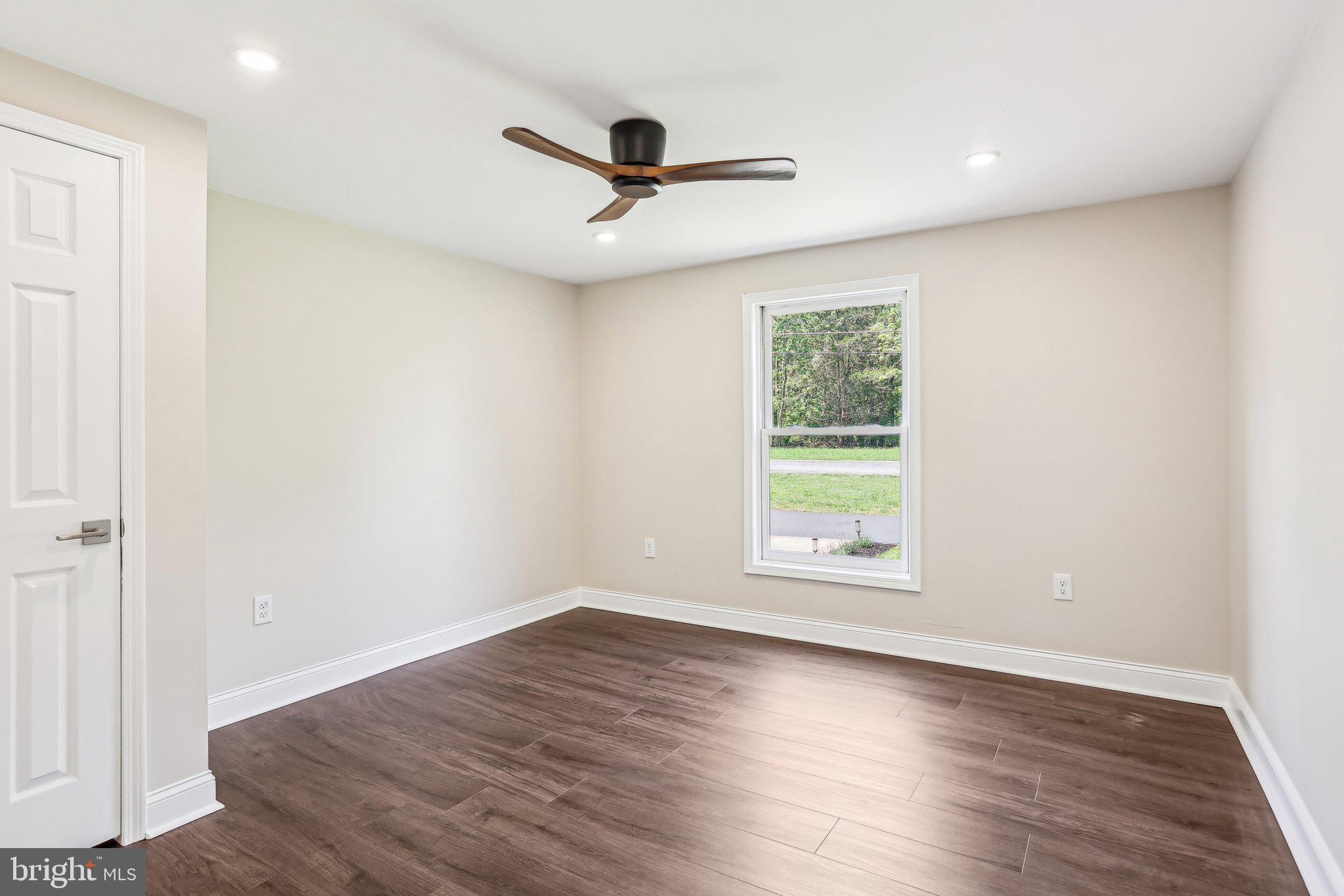 302 Fenwick Road Pilesgrove, NJ 08098 - Photo 25 of 51 an empty room with wooden floor ceiling fan and windows