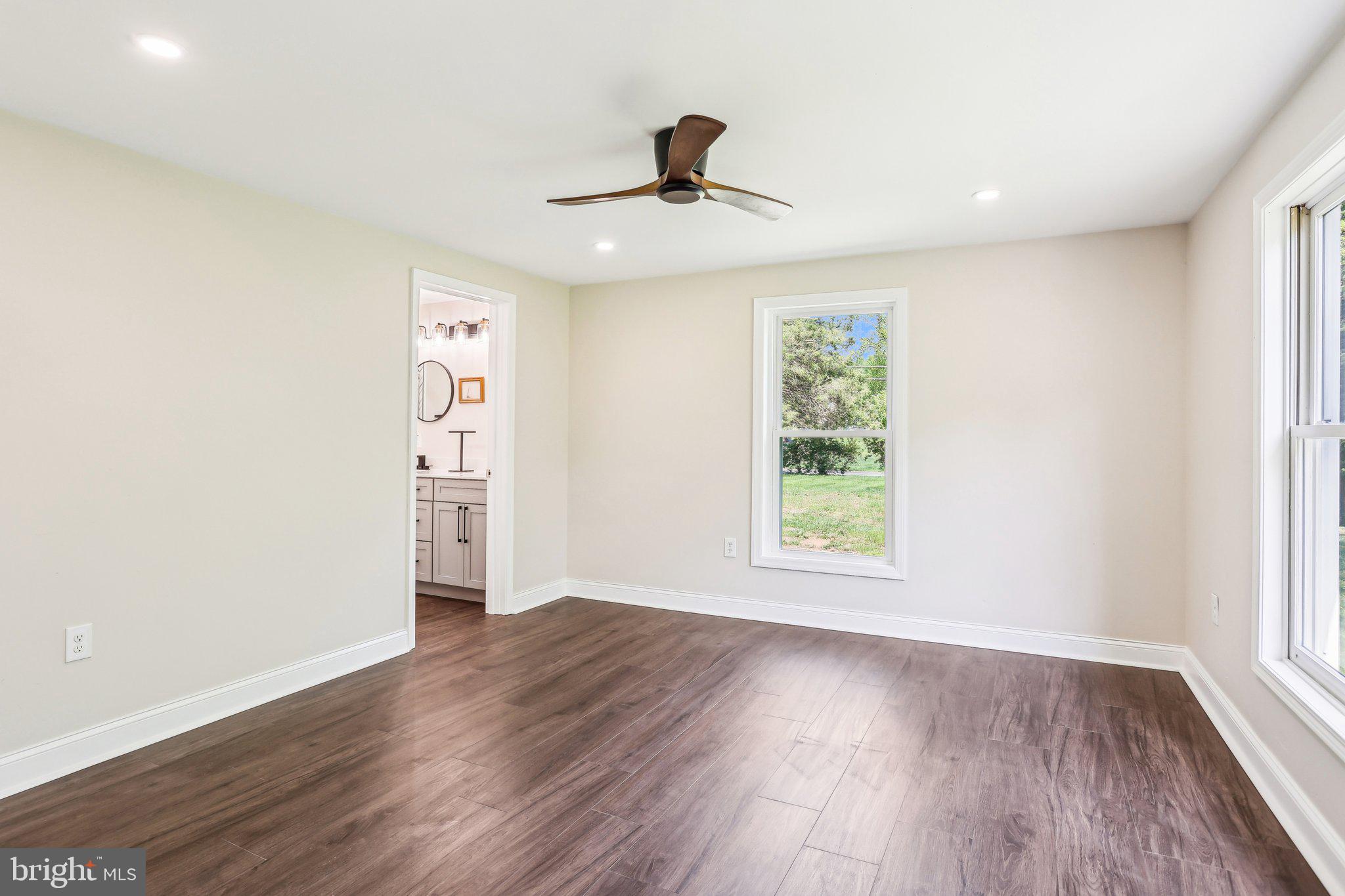 302 Fenwick Road Pilesgrove, NJ 08098 - Photo 33 of 51 an empty room with wooden floor chandelier fan and windows