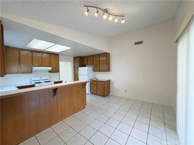 a kitchen with stainless steel appliances a sink a stove top oven a counter space and cabinets