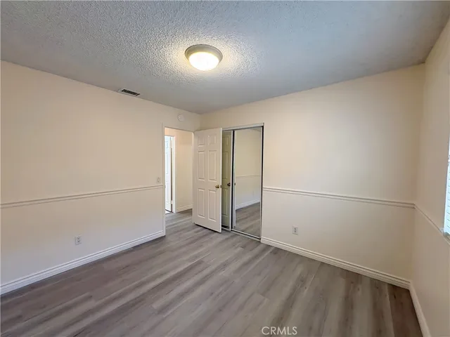 an empty room with wooden floor and white walls