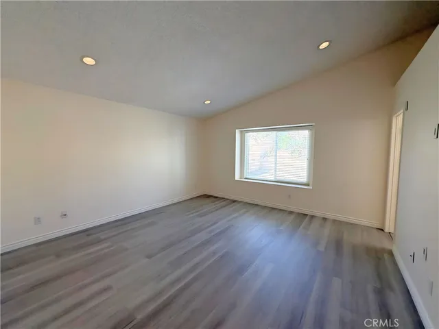 an empty room with wooden floor and window