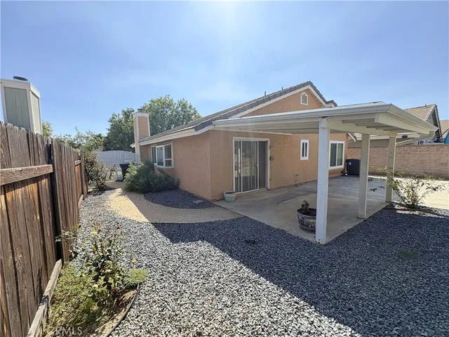 a view of a grey house with a yard and garage