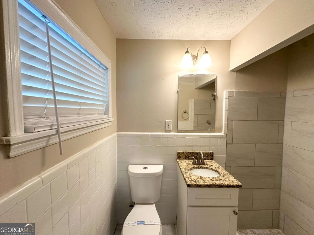 3456 Spring Circle Decatur, GA 30032 - Photo 9 of 22 a bathroom with a toilet a sink and mirror