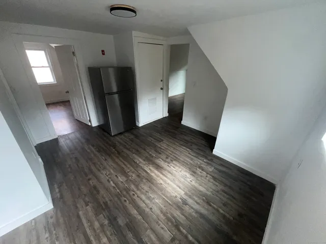 a view of a hallway with wooden floor and stairs