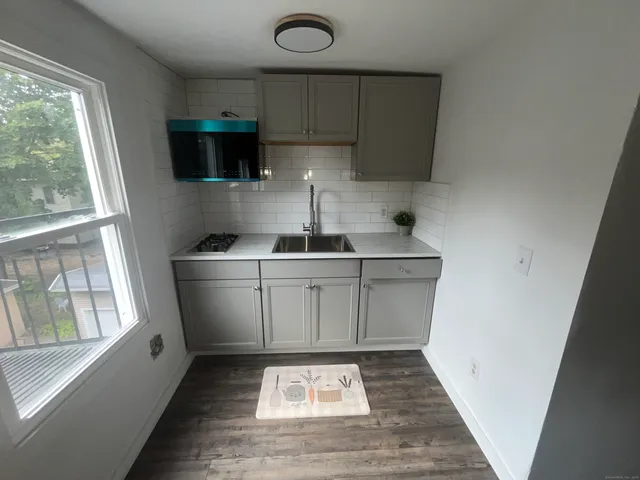 a kitchen with a sink a stove a microwave and cabinets