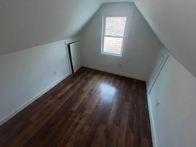 a view of a room with wooden floor and windows