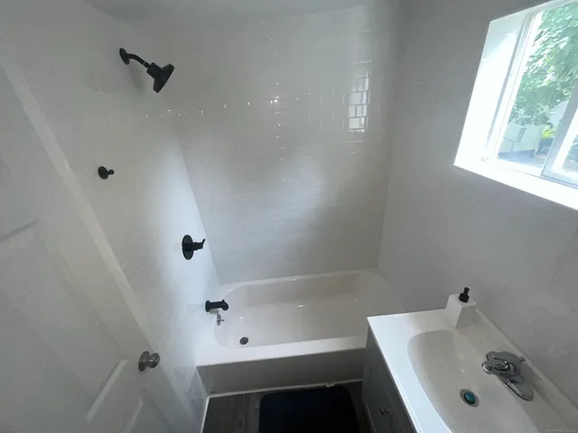 a bathroom with a tub a sink and a window