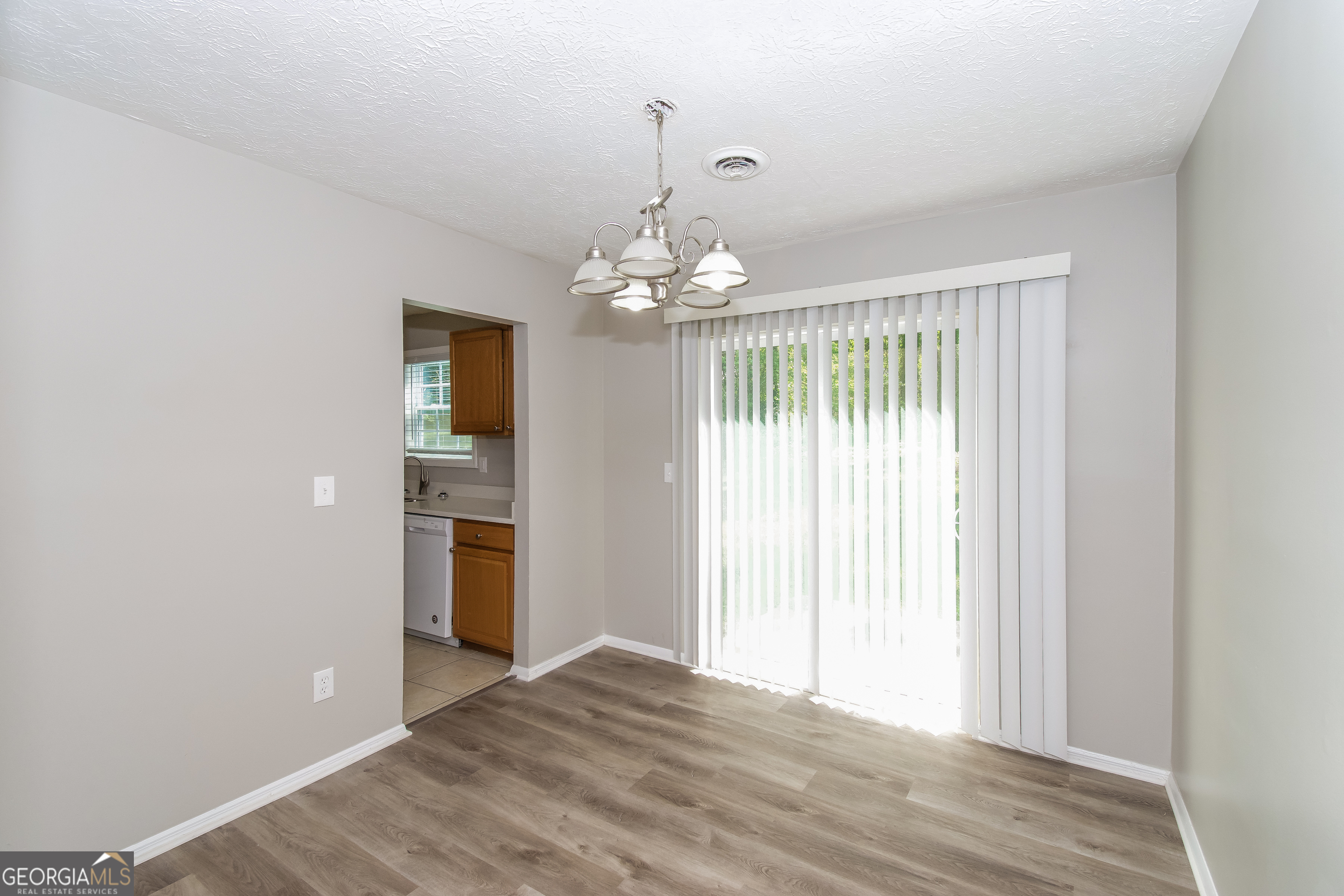 2215 Fairway Circle Southwest Atlanta, GA 30331 - Photo 8 of 18 a view of a chandelier in an empty room with wooden floor and a bedroom