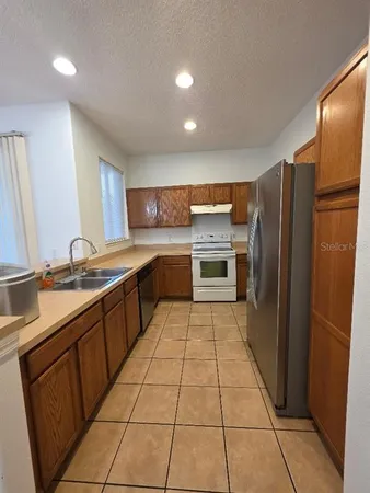 a kitchen with a sink refrigerator and cabinets