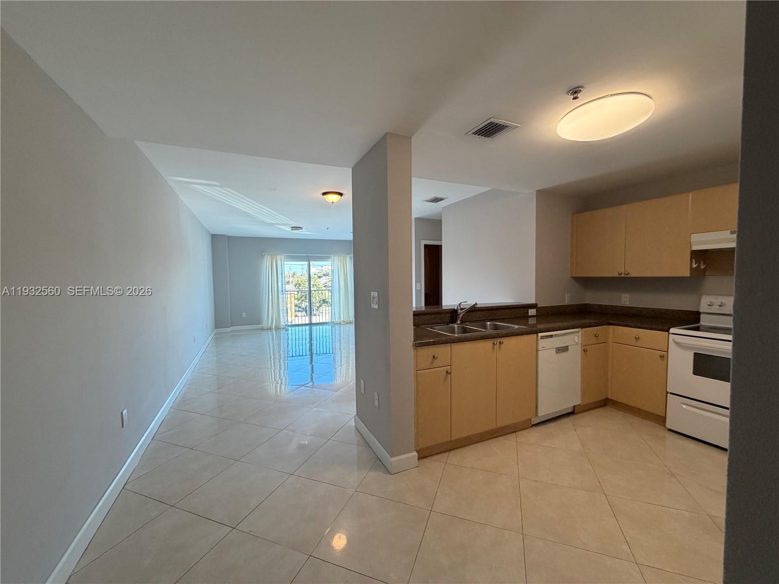 2280 Southwest 32nd Avenue, Unit 216 Miami, FL 33145 - Photo 14 of 34 a large white kitchen with granite countertop a sink