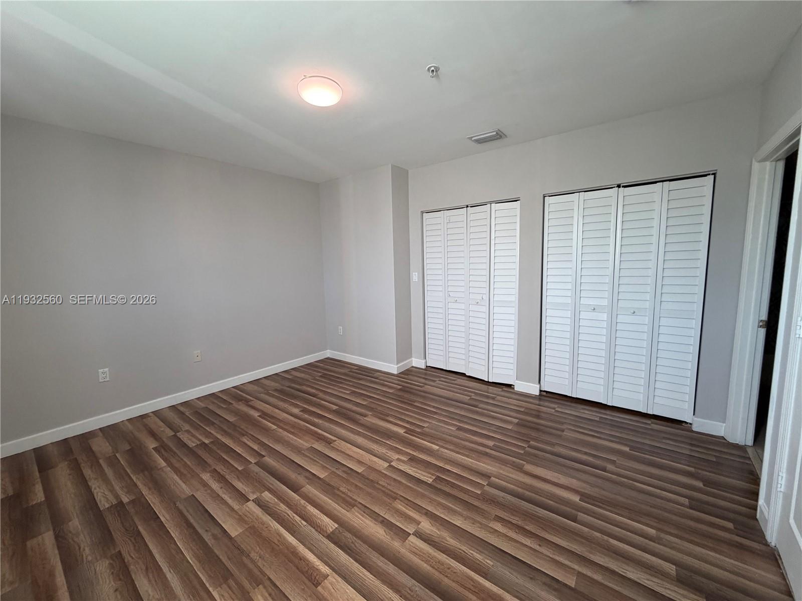 2280 Southwest 32nd Avenue, Unit 216 Miami, FL 33145 - Photo 22 of 34 a view of an empty room with wooden floor and a window