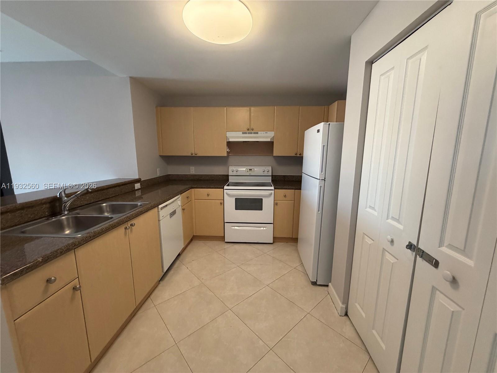 2280 Southwest 32nd Avenue, Unit 216 Miami, FL 33145 - Photo 8 of 34 a kitchen with a sink a refrigerator and cabinets