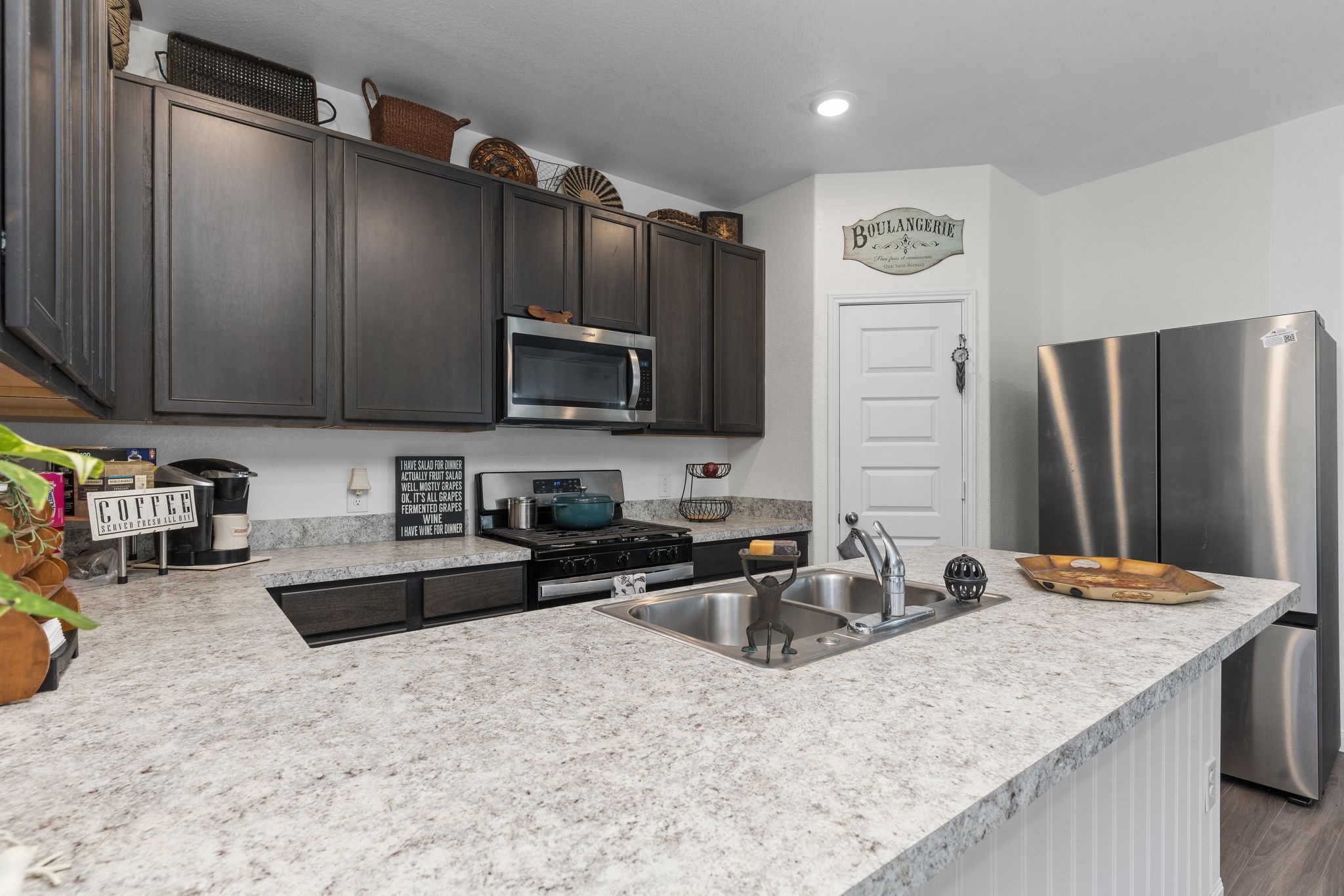22565 Cormorant Court Splendora, TX 77372 - Photo 14 of 50 a kitchen with stainless steel appliances granite countertop a sink refrigerator and microwave