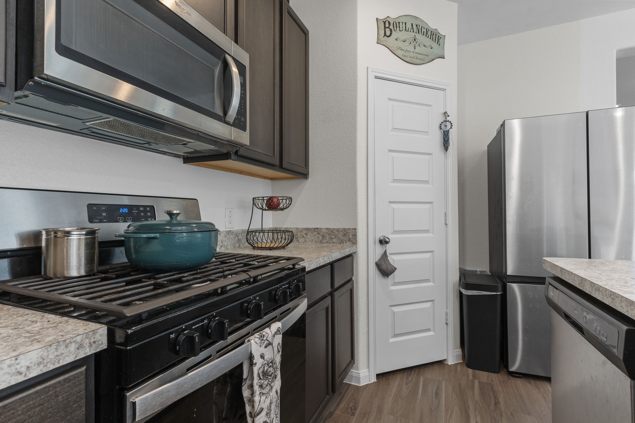22565 Cormorant Court Splendora, TX 77372 - Photo 16 of 50 a kitchen with a stove microwave and refrigerator