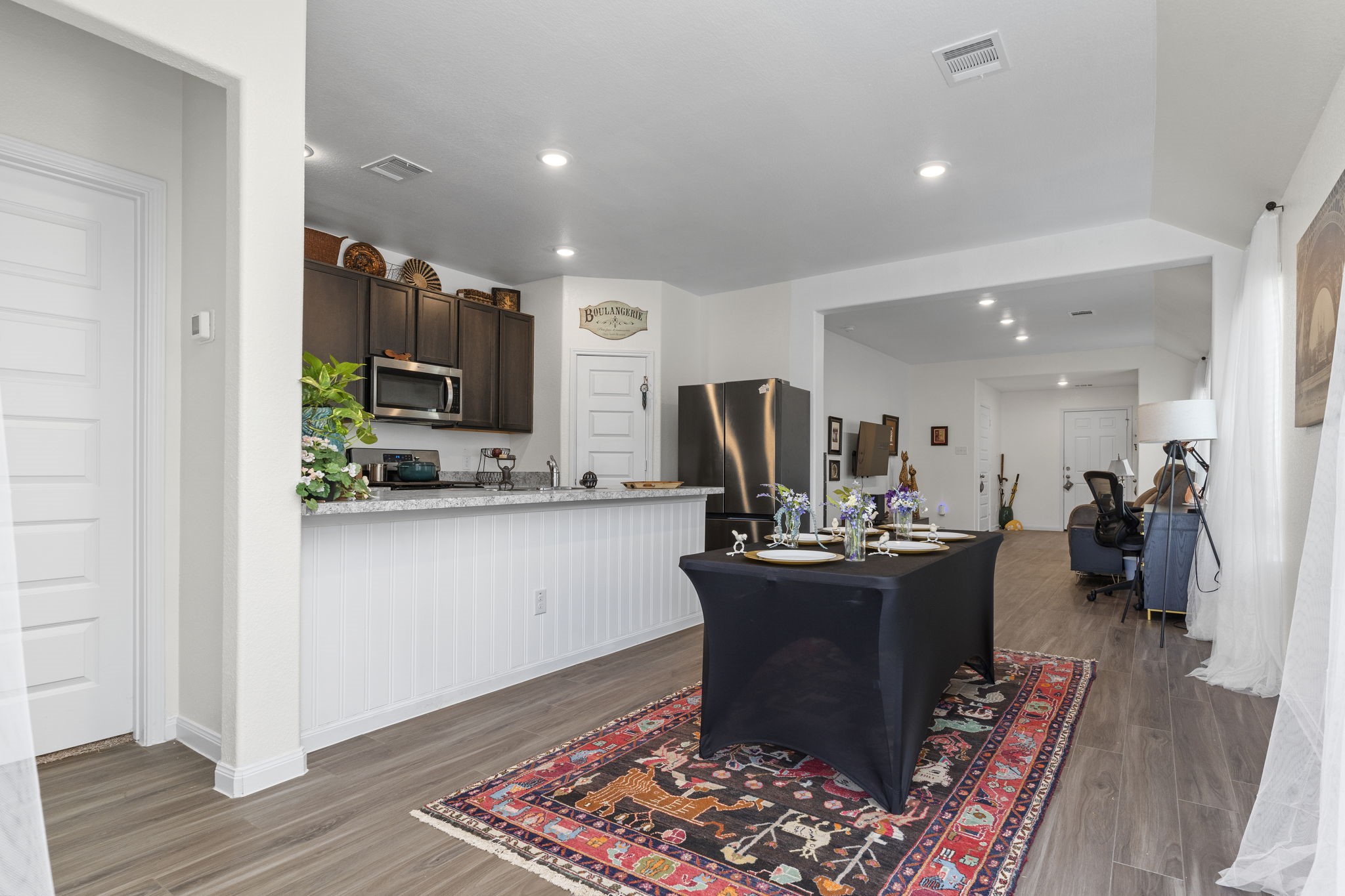 22565 Cormorant Court Splendora, TX 77372 - Photo 22 of 50 a kitchen with kitchen island granite countertop stainless steel appliances a sink cabinets and wooden floor