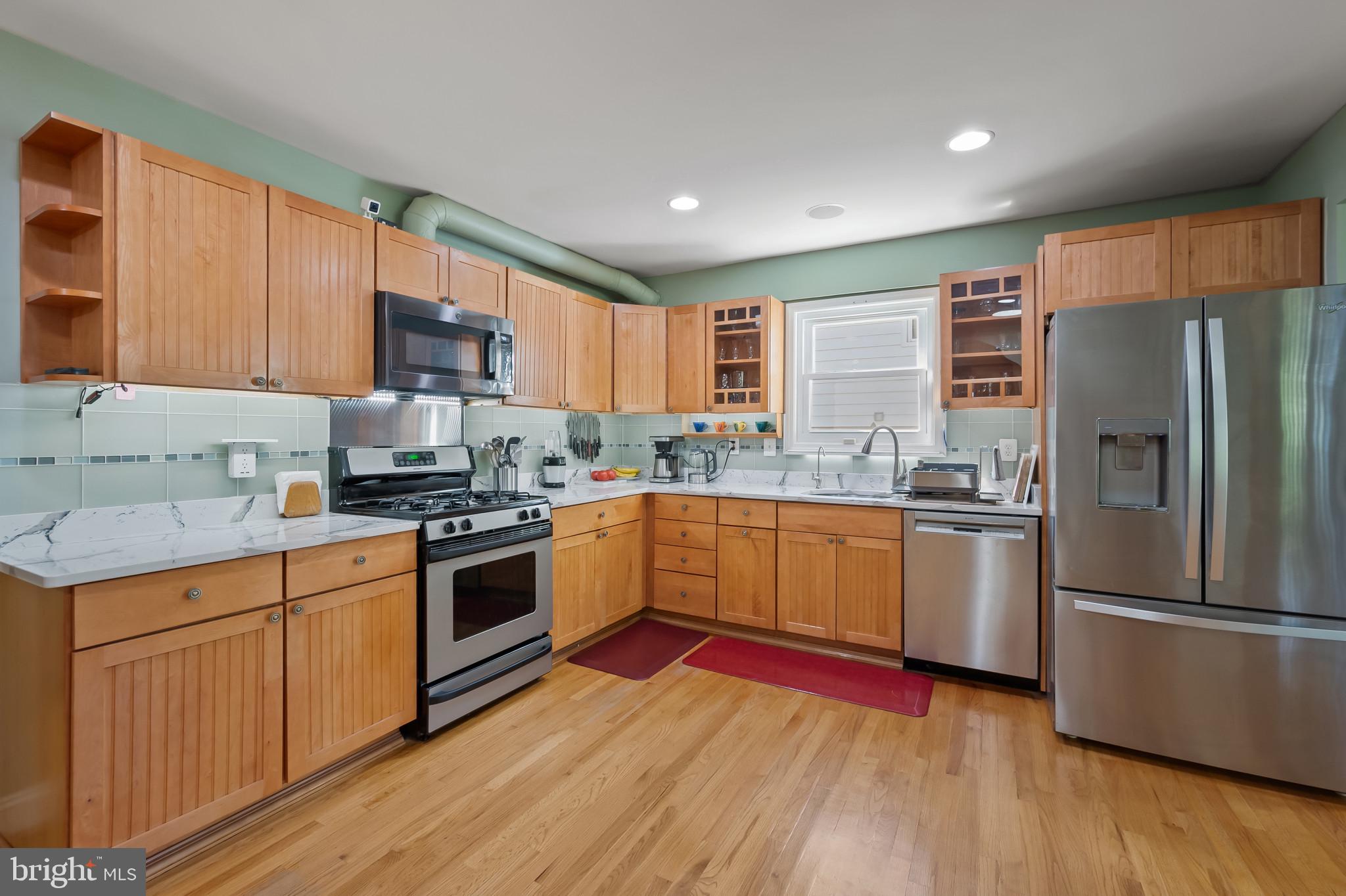 11105 Waycross Way Kensington, MD 20895 - Photo 5 of 35 a kitchen with stainless steel appliances granite countertop a refrigerator a sink dishwasher a stove with wooden cabinets and floor