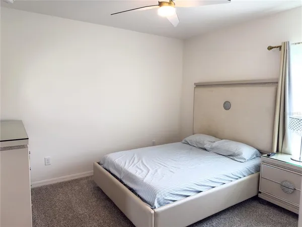 a bedroom with a bed and a lamp with the table