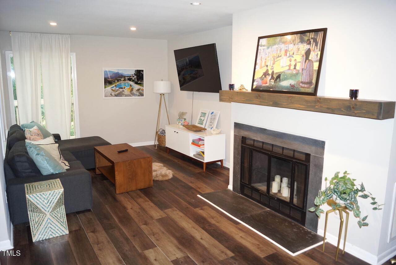 80 Stoneridge Road Durham, NC 27705 - Photo 3 of 27 a living room with furniture a flat screen tv and a fireplace