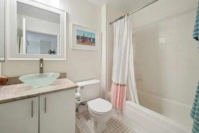 a bathroom with a granite countertop sink toilet and shower