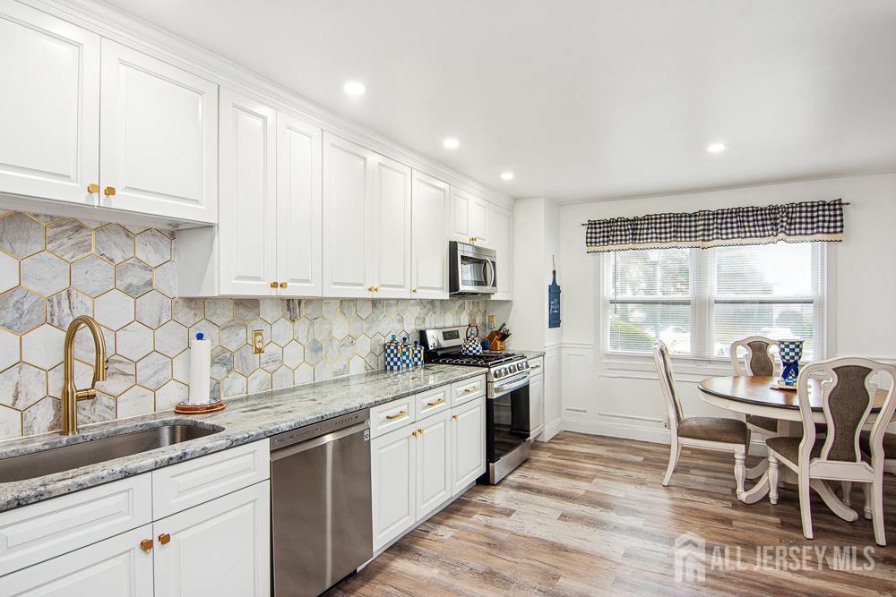 a kitchen with granite countertop white cabinets and white appliances