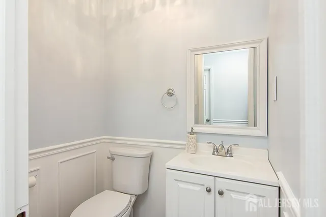 a bathroom with a toilet a sink and mirror