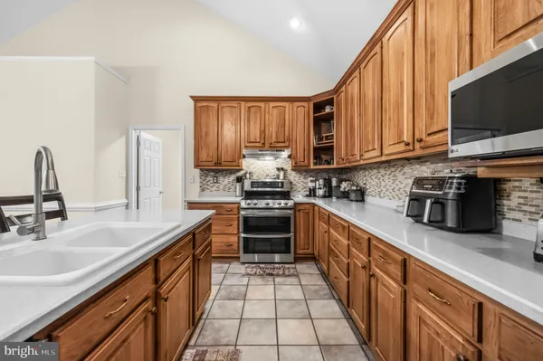 a kitchen with stainless steel appliances a stove sink microwave and cabinets