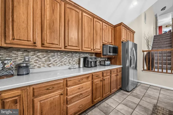 a kitchen with stainless steel appliances granite countertop a refrigerator a sink a stove and cabinets