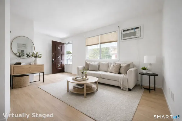 a living room with furniture a rug and a window