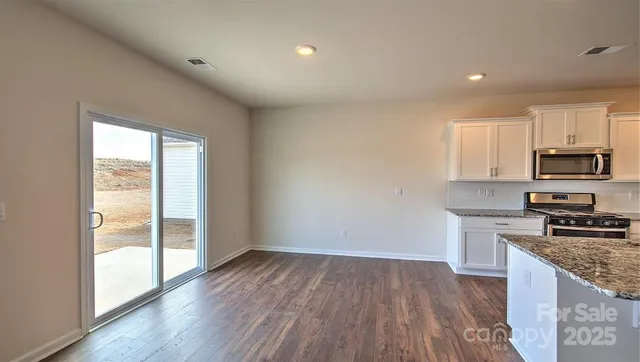 a kitchen with granite countertop wooden floors and stainless steel appliances