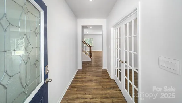 a view of a hallway with wooden floor and entryway