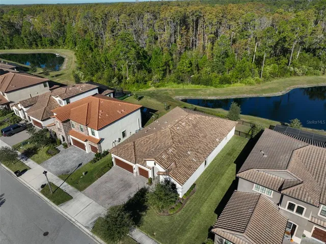 an aerial view of residential houses with outdoor space and lake view