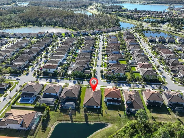 an aerial view of a house with a yard and lake view