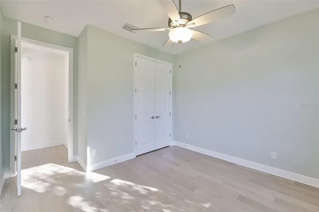 an empty room with a ceiling fan and a window