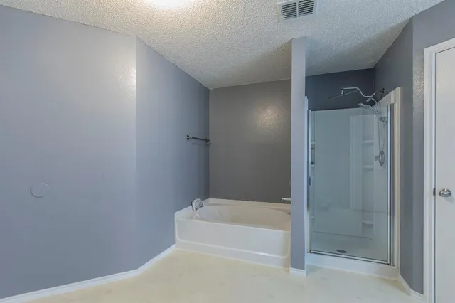 a bedroom with bed and a flat tv screen on dresser