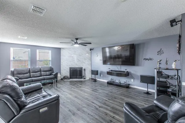a living room with furniture a flat screen tv and a fireplace