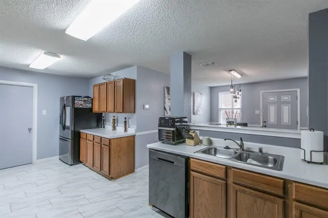 a kitchen with microwave a sink and cabinets