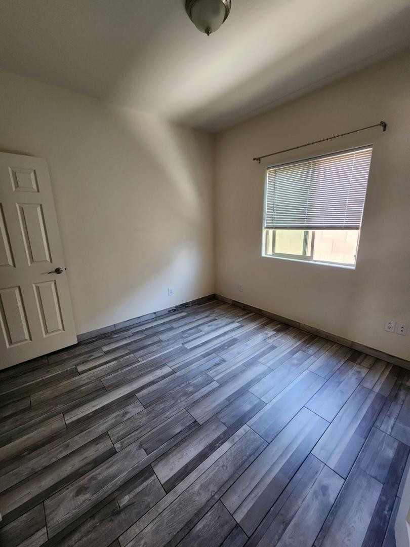 3641 Camino Del Rancho Douglas, AZ 85607 - Photo 11 of 20 a view of an empty room with wooden floor and a window