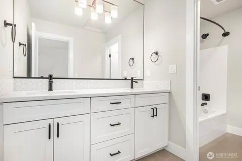 a bathroom with double vanity sink a mirror and shower