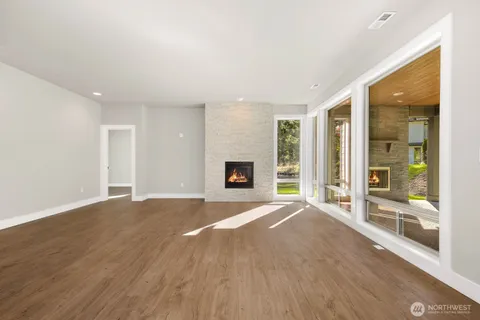 a view of a livingroom with wooden floor and a fireplace