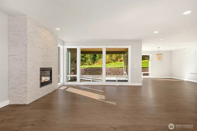 a view of a livingroom with wooden floor and a fireplace