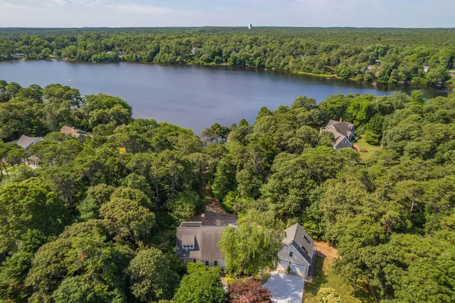 an aerial view of a residential houses with outdoor space and lake view