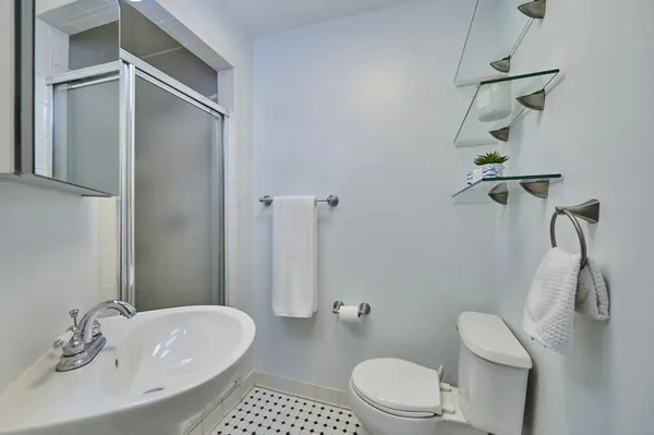 a bathroom with a sink a toilet and shower