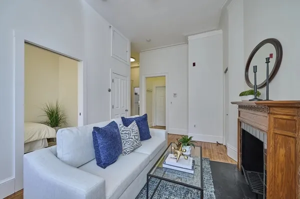 a living room with furniture a mirror and a fireplace