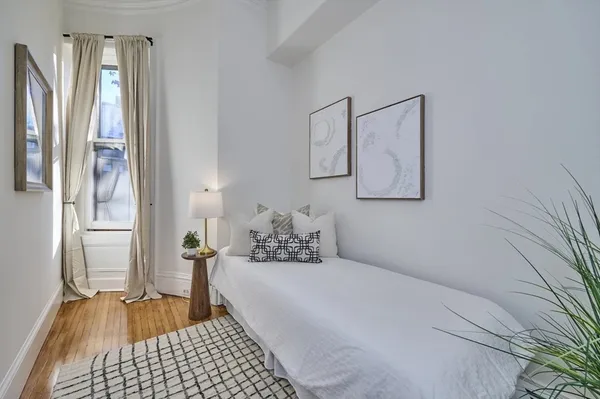 a bedroom with a bed and wooden floor