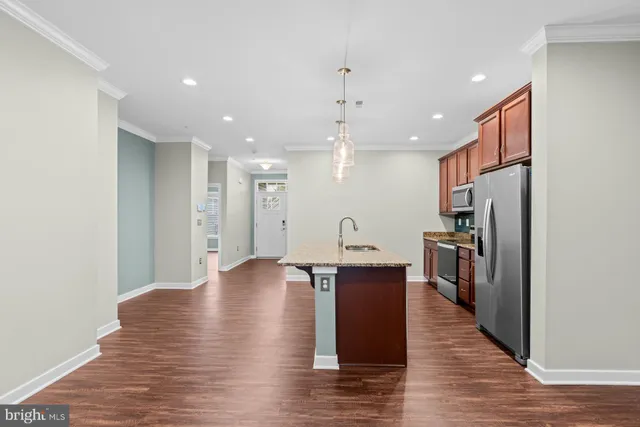 a view of kitchen with cabinets stainless steel appliances and wooden floor
