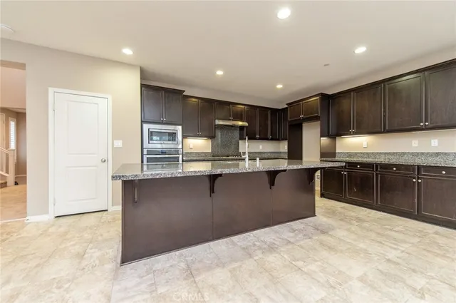 a view of kitchen with stainless steel appliances refrigerator microwave and stove
