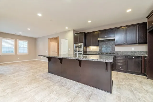an empty room with kitchen view and a window