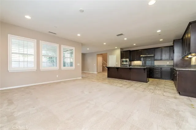 a open kitchen with stainless steel appliances granite countertop a refrigerator and a sink