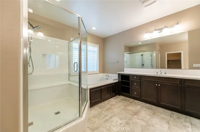 a spacious bathroom with a granite countertop sink a mirror and a shower
